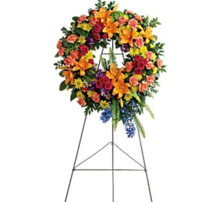 <div id="mark-1" class="m-pdp-tabs-marketing-description">Like a beacon of love and hope, this glorious wreath of hydrangea, roses and lilies echoes the joy of your precious memories.</div>
<div id="desc-1">
<ul>
 	<li>This wreath features green hydrangea, hot pink spray roses, orange asiatic lilies, orange carnations, blue delphinium, purple stock, yellow cushion spray chrysanthemums, huckleberry, variegated pittosporum, sword fern, silver dollar eucalyptus, and lemon leaf.</li>
 	<li>Delivered on a wire easel.</li>
</ul>
</div>
