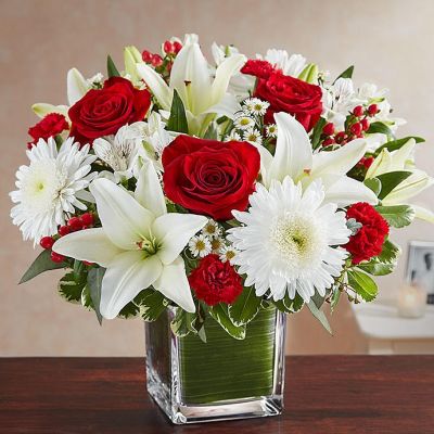 The color most related the heart, let red serve as a reminder that you're thinking of them. Our arrangement of timeless red roses, carnations, and white lilies, expertly gathered together in a clear vase, it is an exquisite gesture of sentiment and caring.